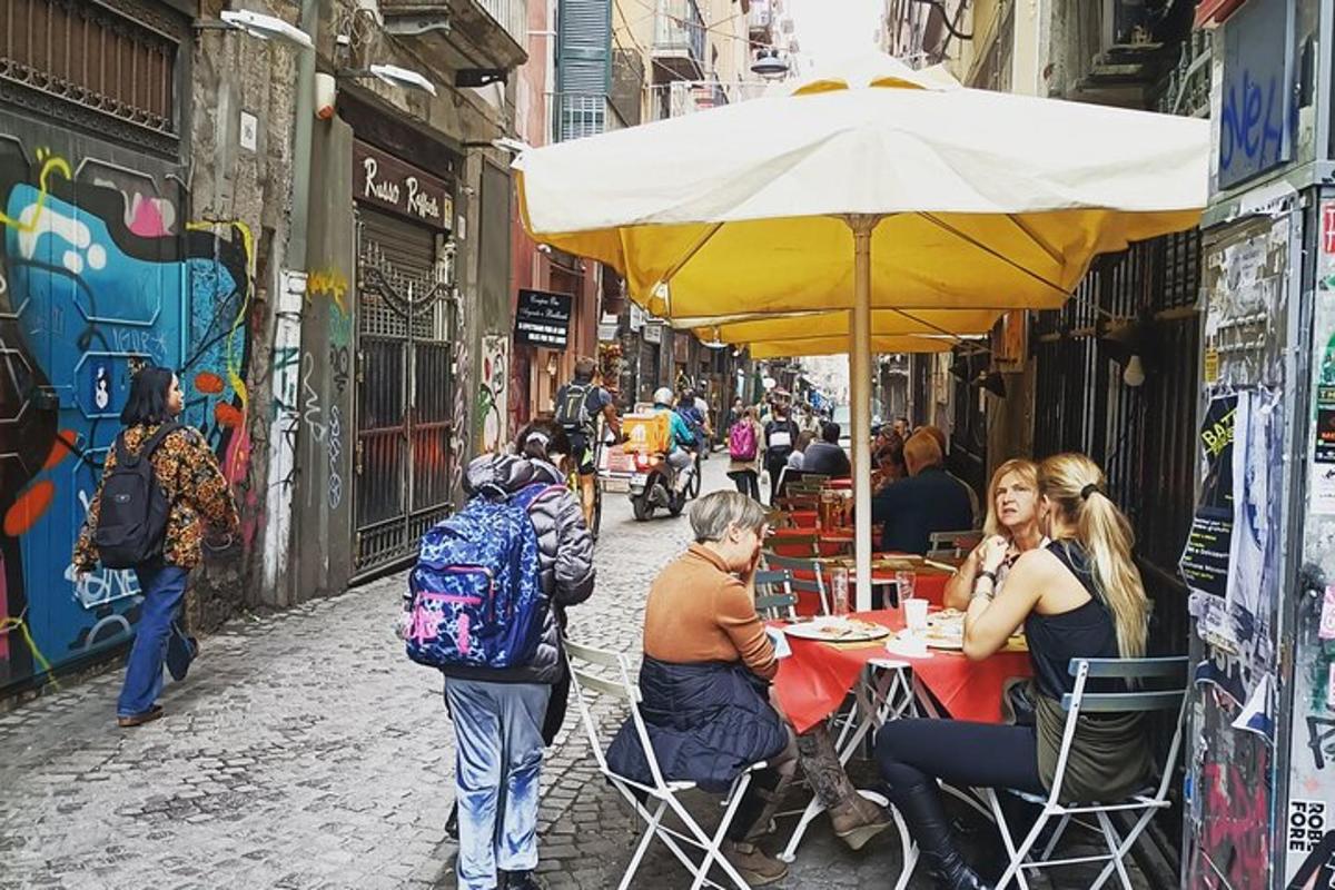 un gruppo di persone sedute a un tavolo sotto un ombrellone