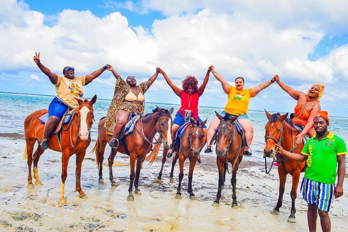 um grupo de pessoas andando a cavalo na praia