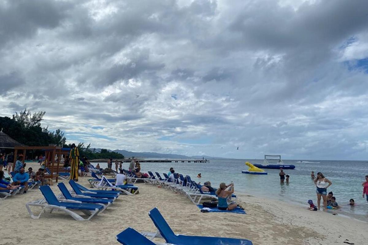 um grupo de pessoas em uma praia com cadeiras e o oceano