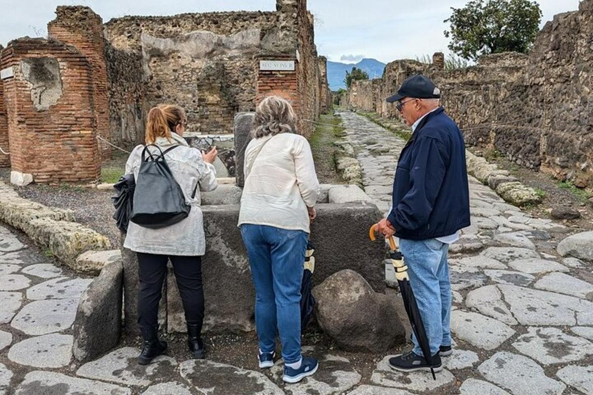 un gruppo di persone in piedi accanto a un muro di pietra