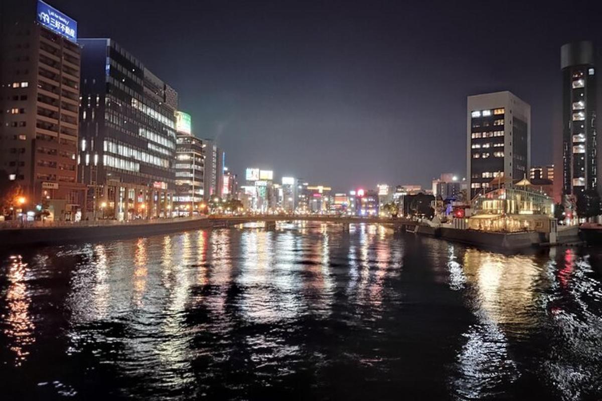 uma cidade à noite com um rio e edifícios