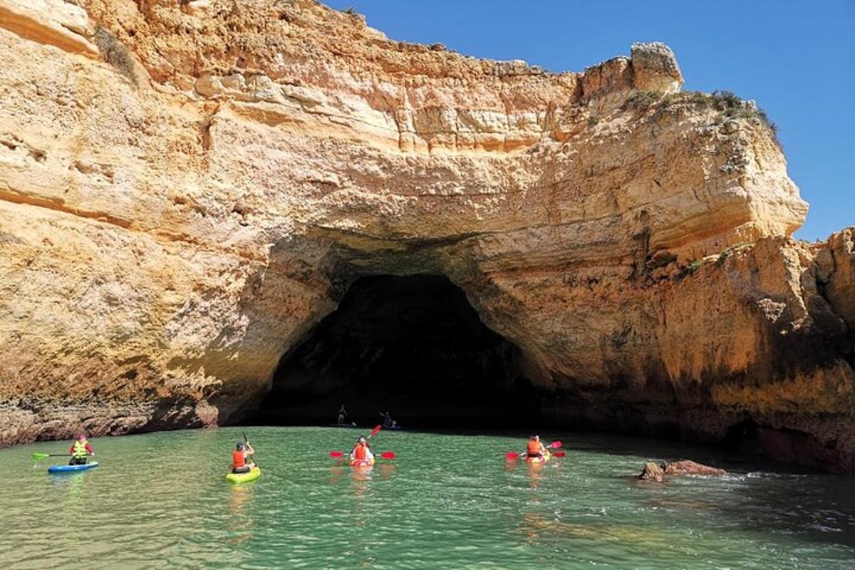 un gruppo di persone nell'acqua di fronte a una grotta