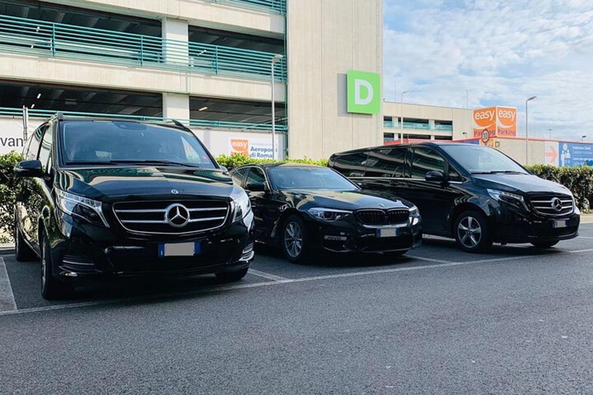 três carros estacionados em um estacionamento em frente a um prédio