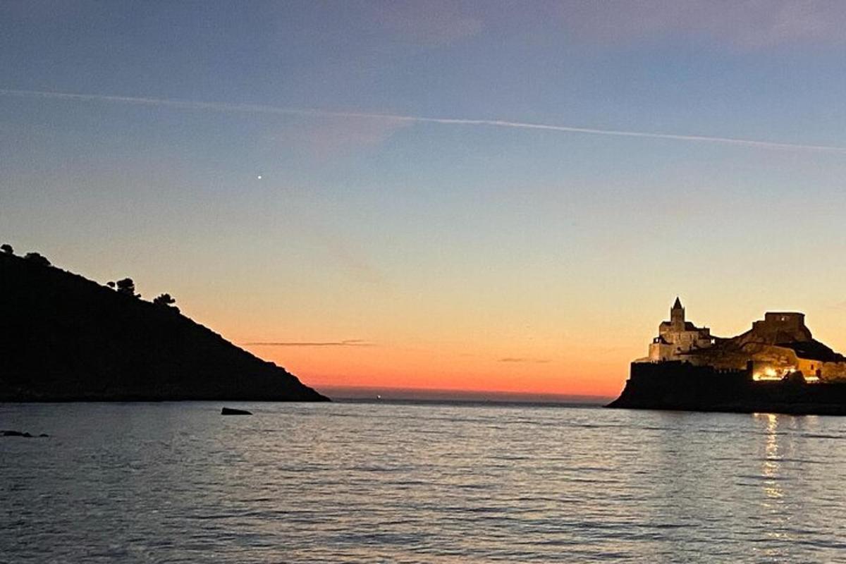 a sunset over a body of water with a castle