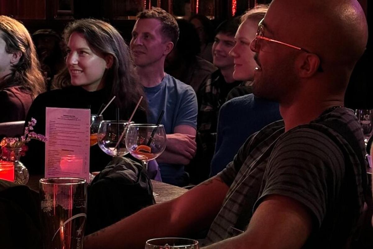 um grupo de pessoas sentadas à mesa com taças de vinho