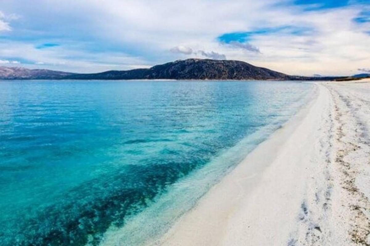 una spiaggia con sabbia bianca e acqua blu