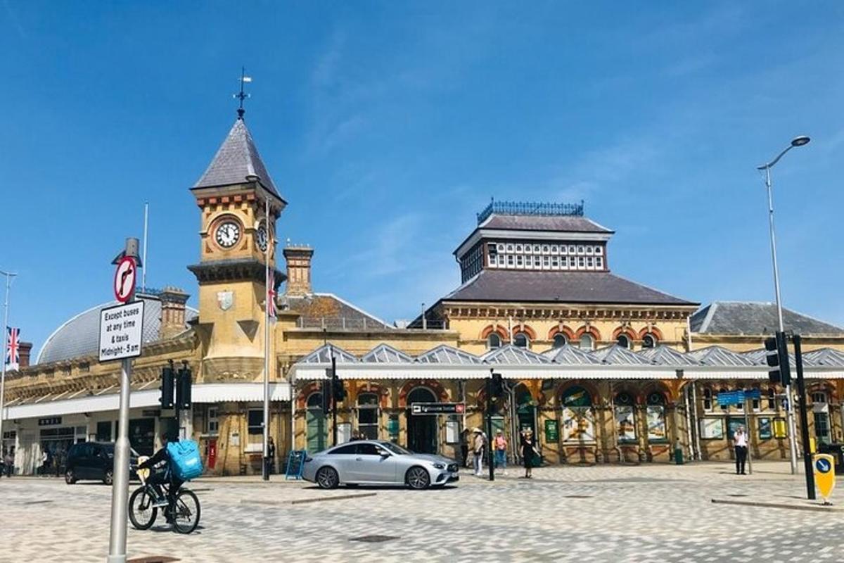 un edificio con una torre dell'orologio con un'auto di fronte
