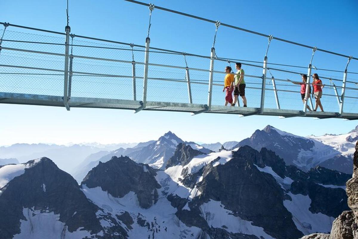 pessoas em uma ponte suspensa sobre as montanhas