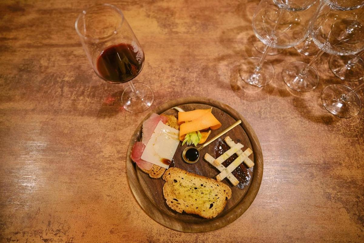 um prato de comida e taças de vinho sobre uma mesa