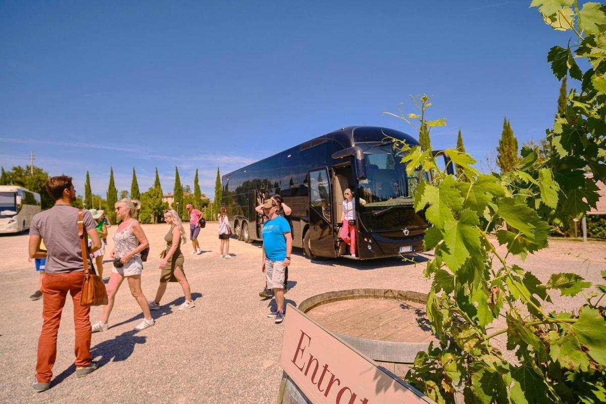 a group of people standing outside of a bus