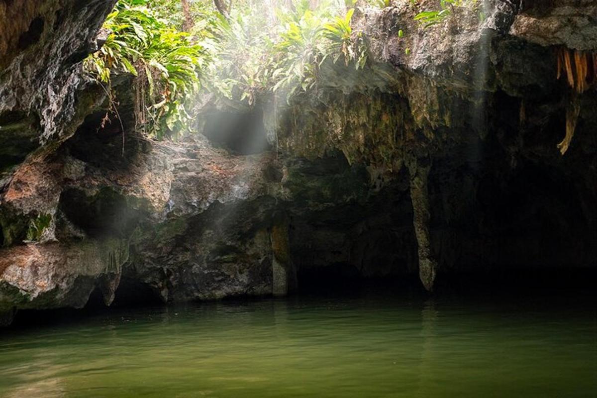 uma caverna com uma piscina de água na frente dela