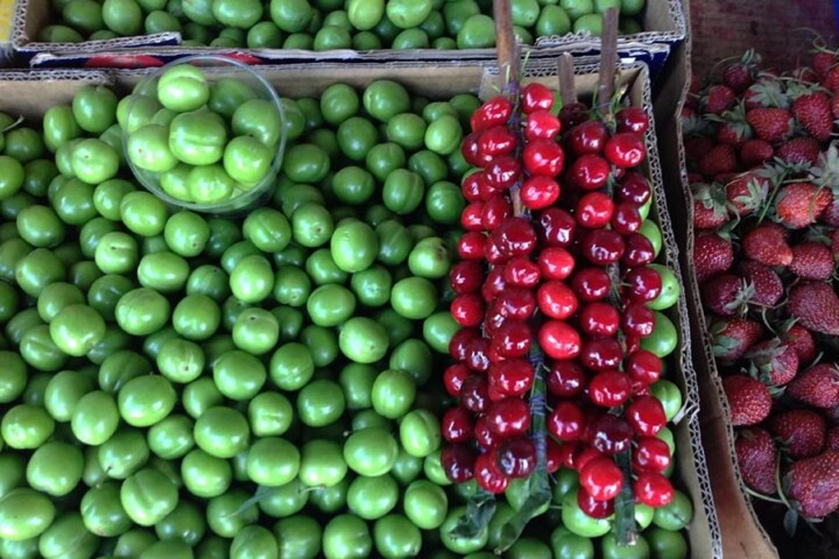 uma exposição de maçãs e morangos verdes e vermelhos