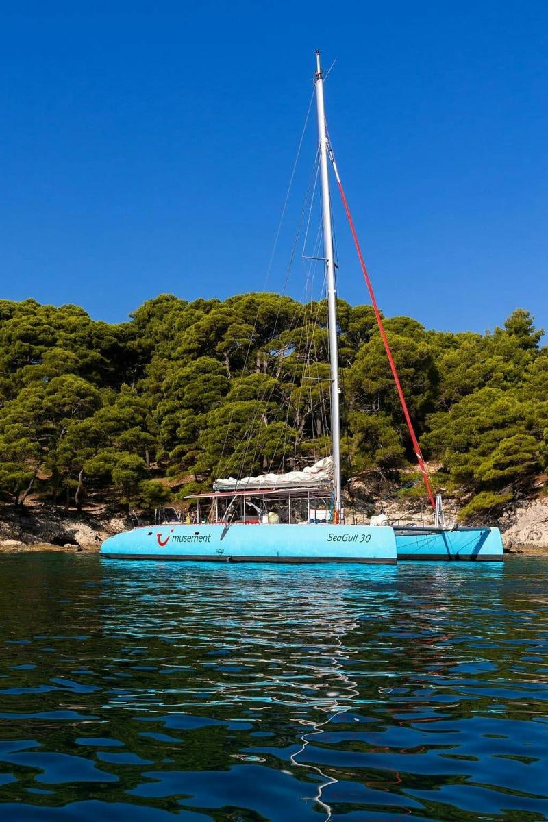 a blue sail boat sitting in the water