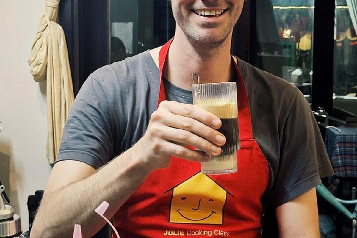 een man met een schort die een glas bier vasthoudt