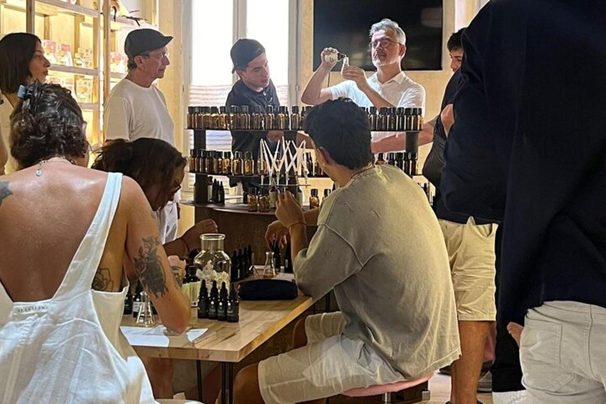 skupina lidí stojících kolem stolu s lahvemi vína