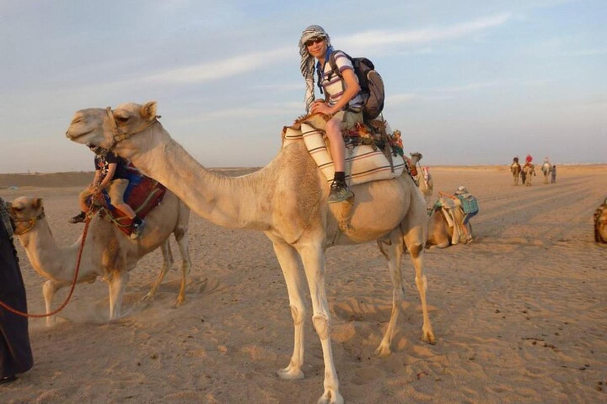 a woman riding on a camel in the desert