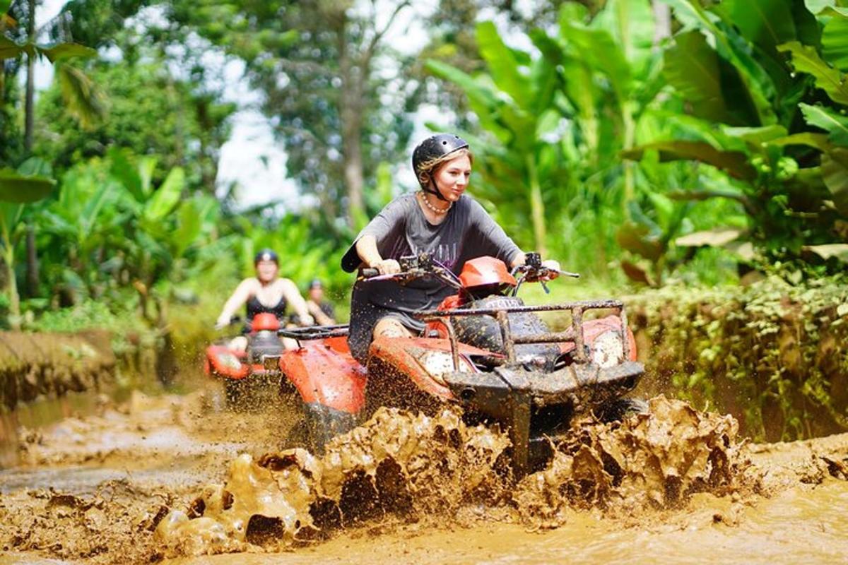 duas pessoas andando de quadriciclo por um campo de terra