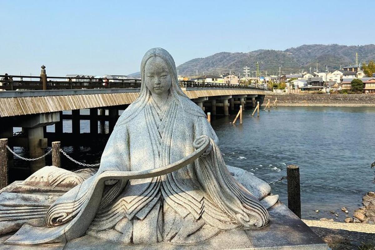 una estàtua d'una dona asseguda al costat d'una massa d'aigua