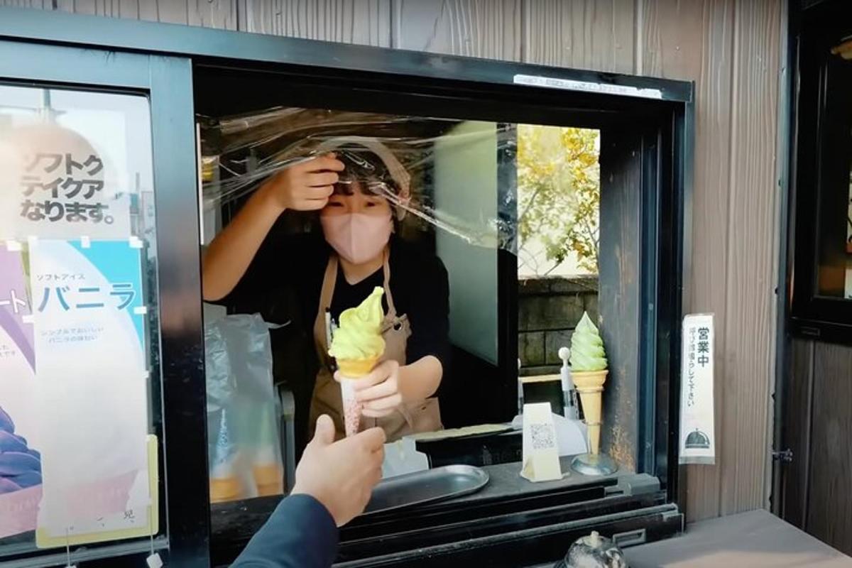 una persona fent una foto d'una dona menjant gelat