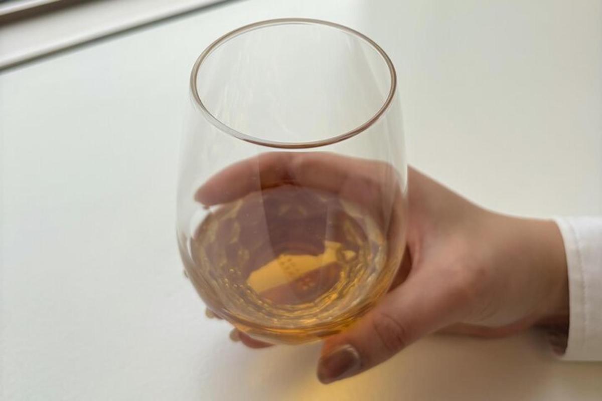 eine Person, die ein Weinglas in der Hand hält