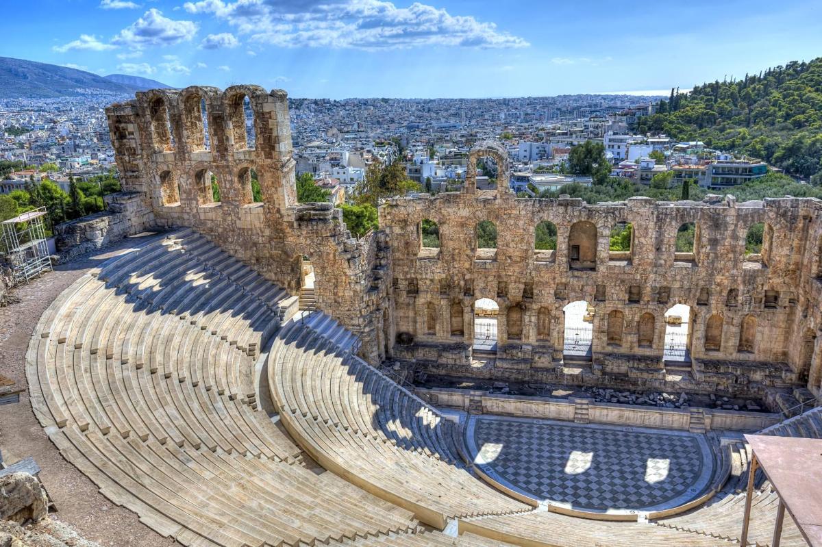an amphitheater with a city in the background