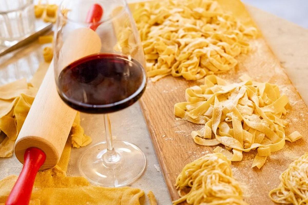 un verre de vin à côté d'une planche à découper avec des pâtes