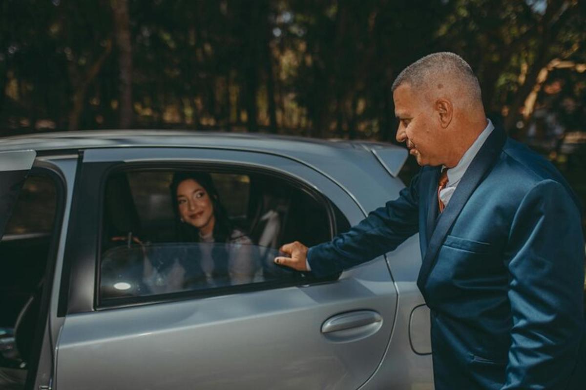 ülikonnas mees seisab auto kõrval