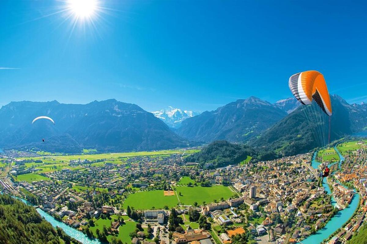 un parapent volant sobre una ciutat i un riu