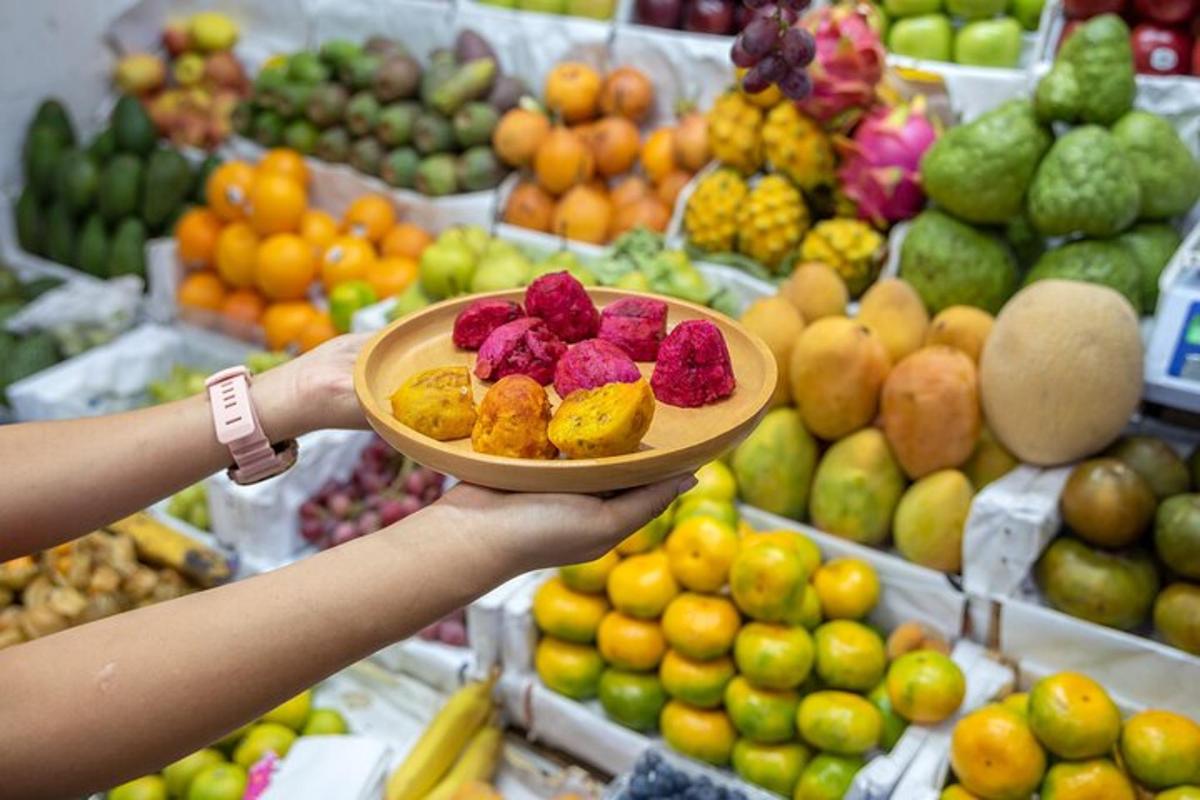 seseorang yang memegang sepinggan buah-buahan di pasar