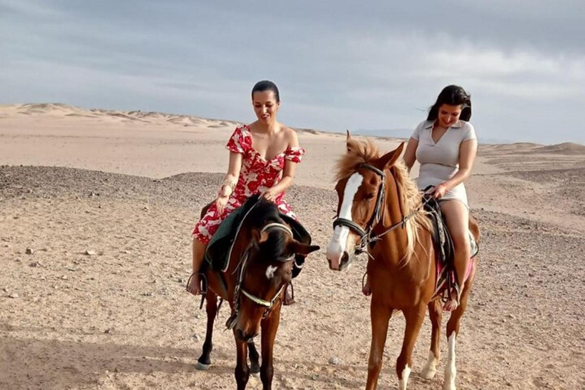 due donne stanno cavalcando cavalli nel deserto