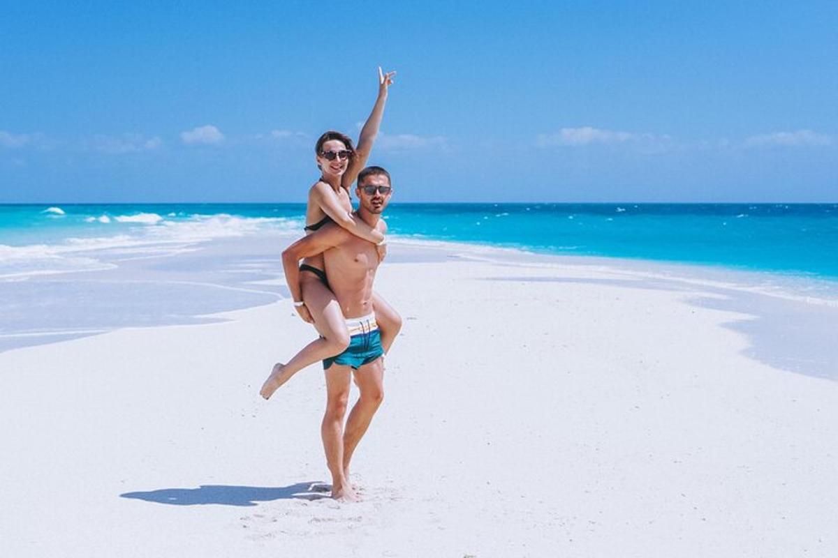 um homem carregando uma mulher na praia