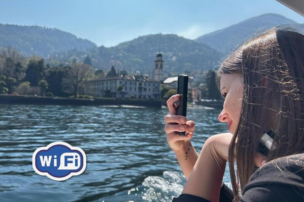 o femeie care fotografiază un râu cu telefonul mobil