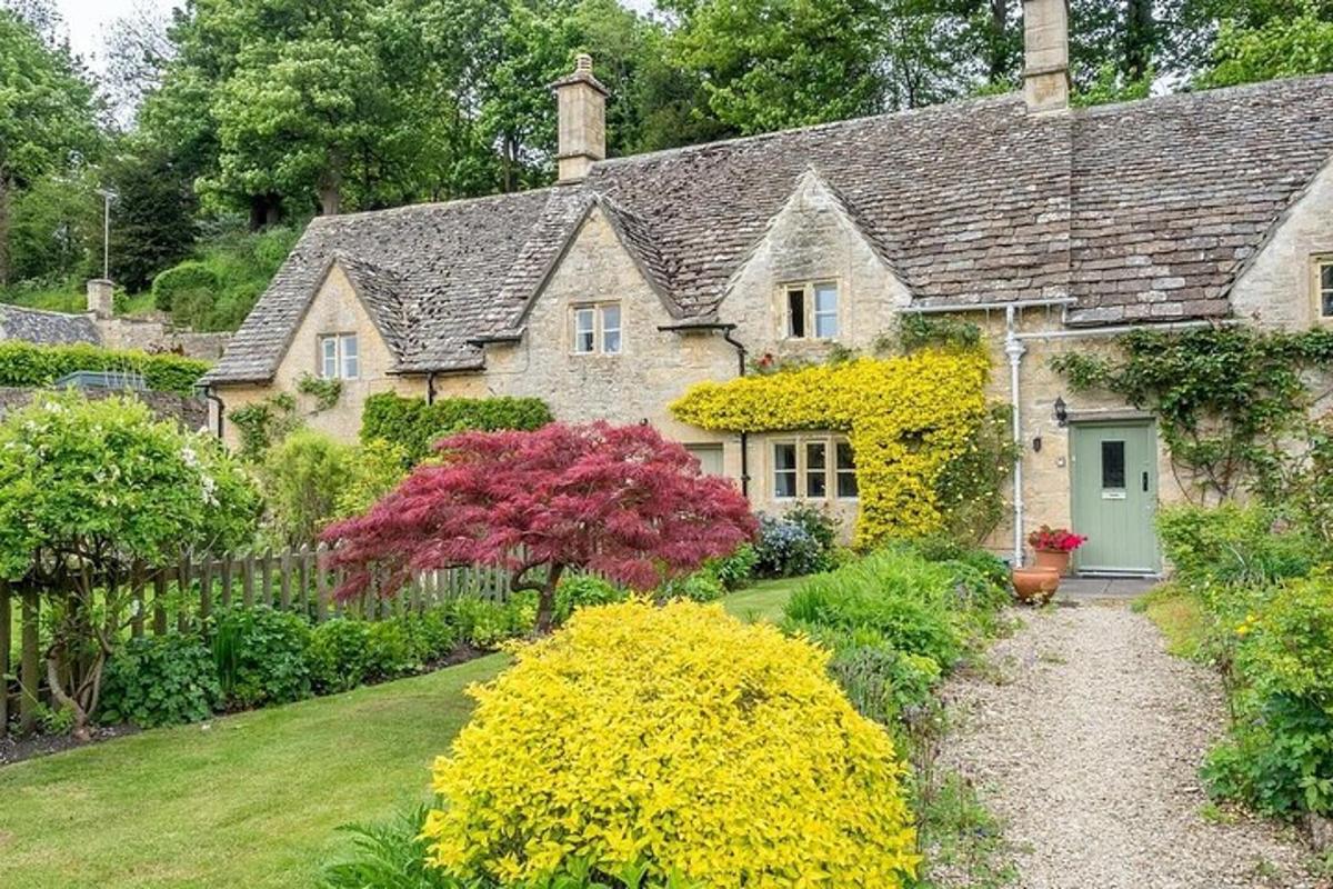 an old stone house with a garden of flowers