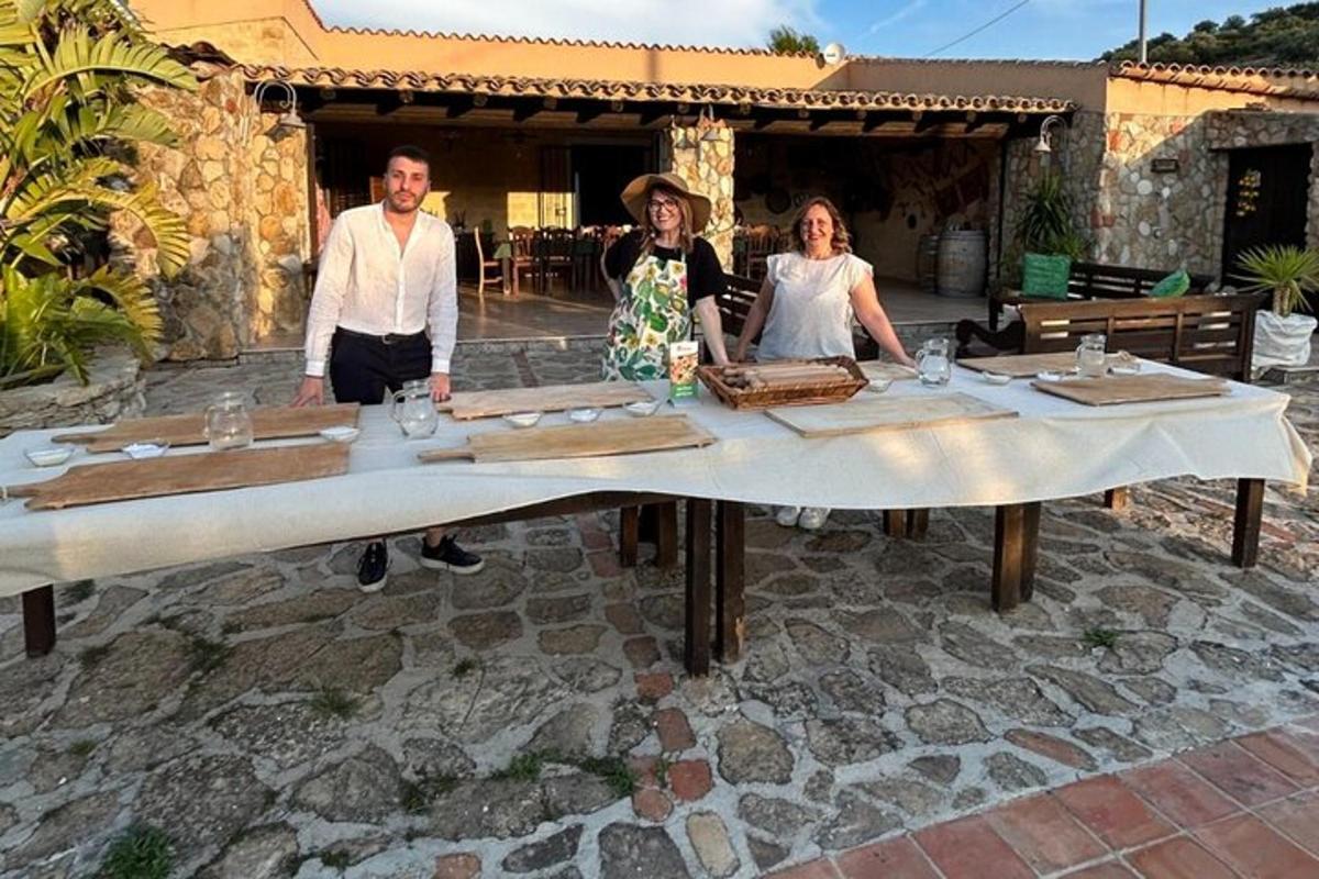 Un grupo de tres personas de pie alrededor de una mesa.