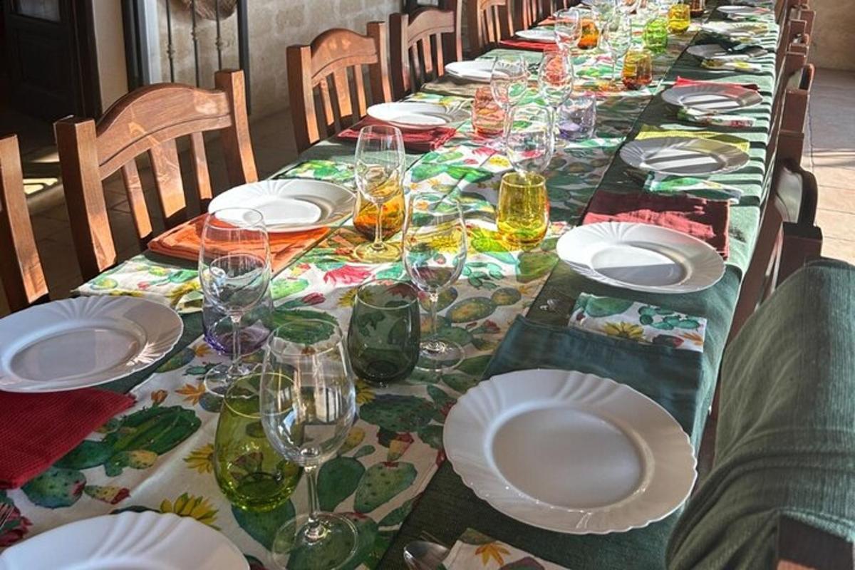 Una mesa larga con platos y copas de vino encima.