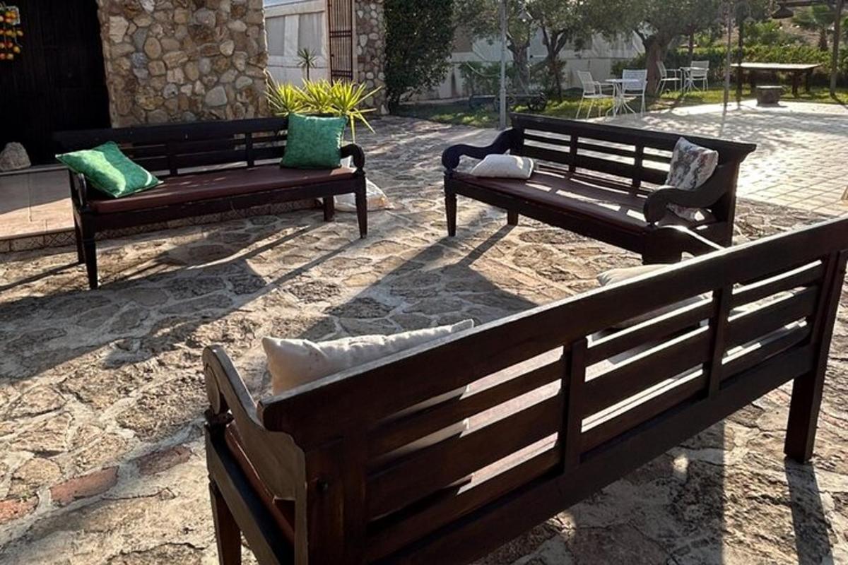 dalawang bench na may mga unan na nakaupo sa isang patio