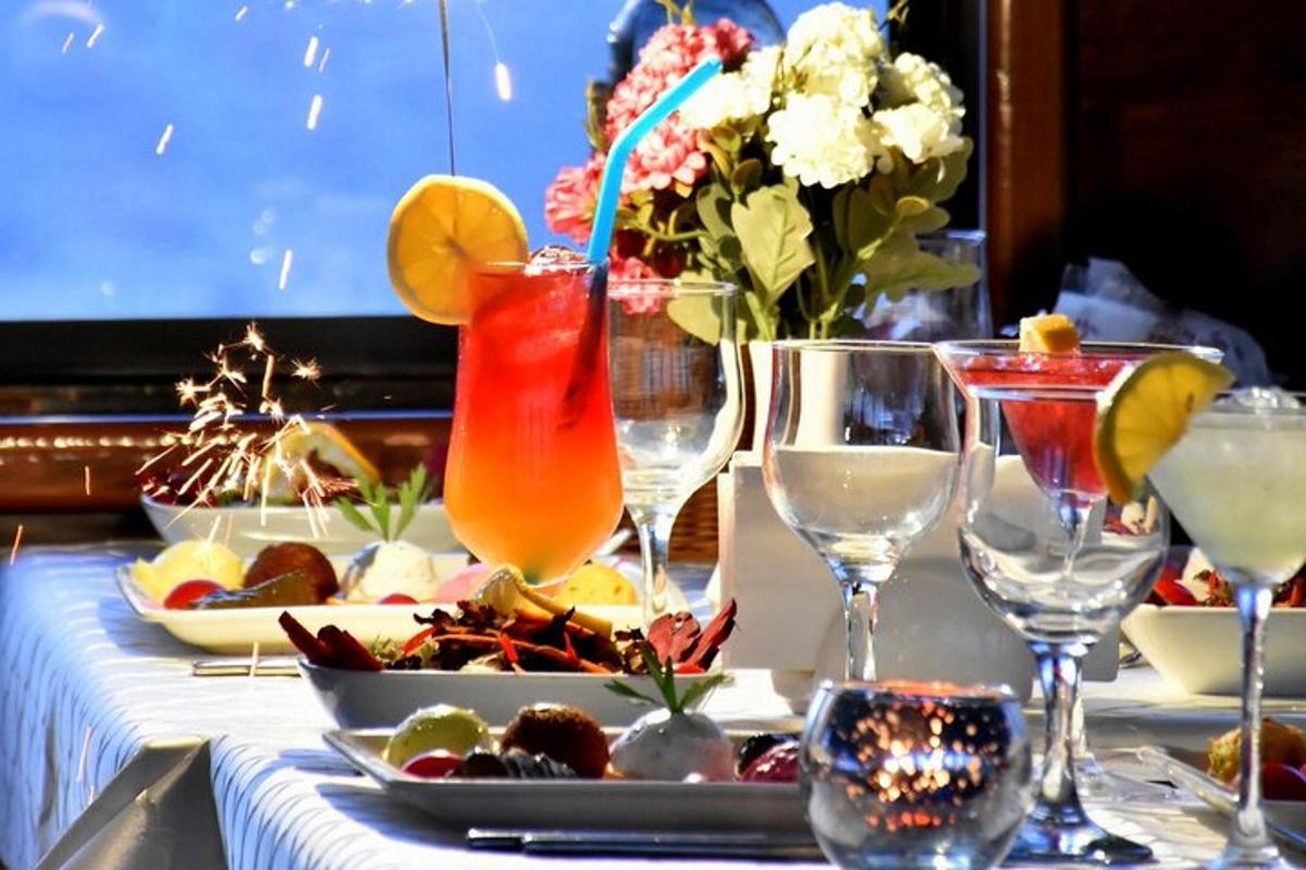 uma mesa com um prato de comida e taças de vinho