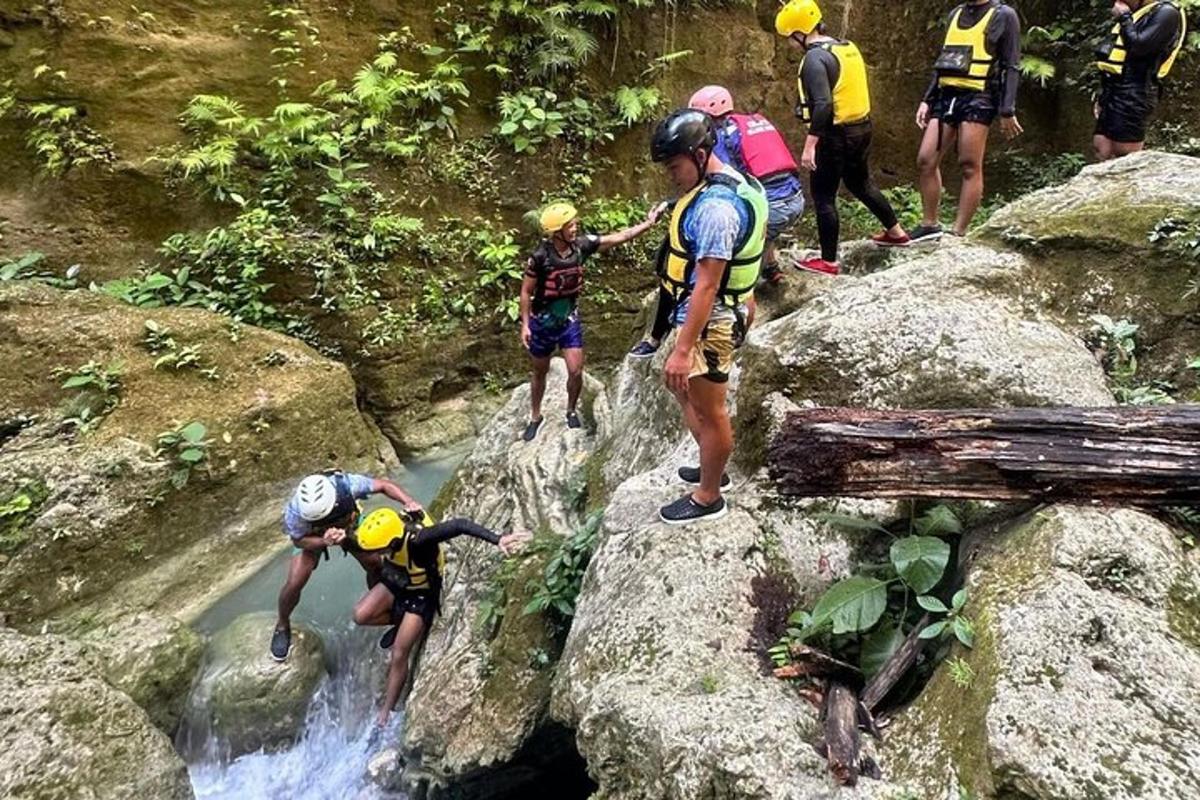 un grup de oameni care stau pe stânci lângă un râu