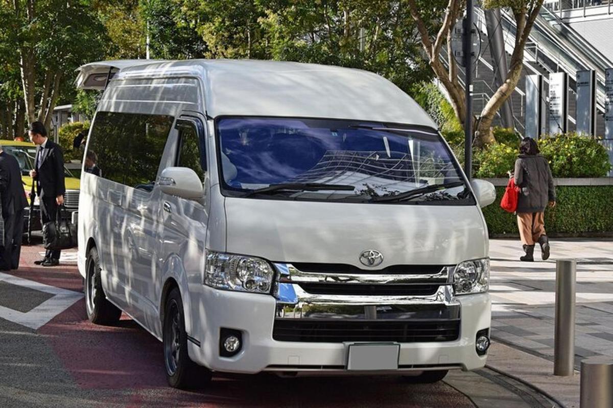 uma van branca estacionada na beira de uma rua