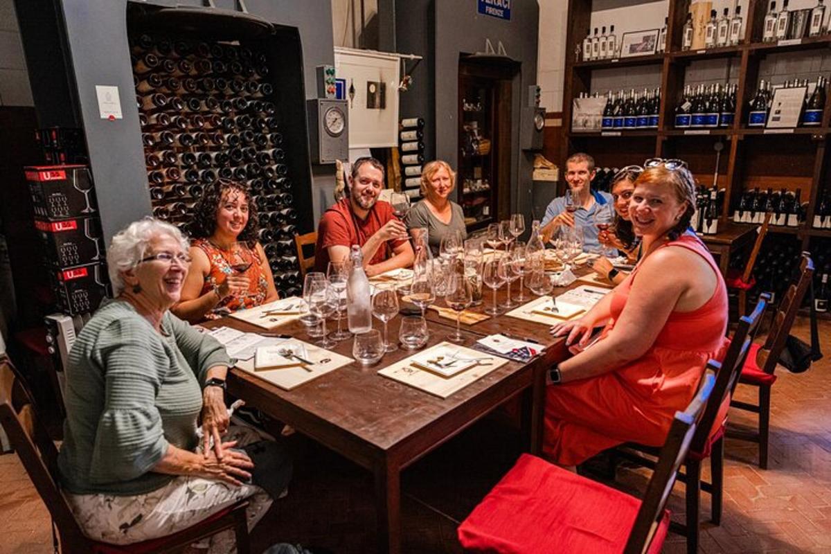 un grup de oameni așezați în jurul unei mese cu pahare de vin