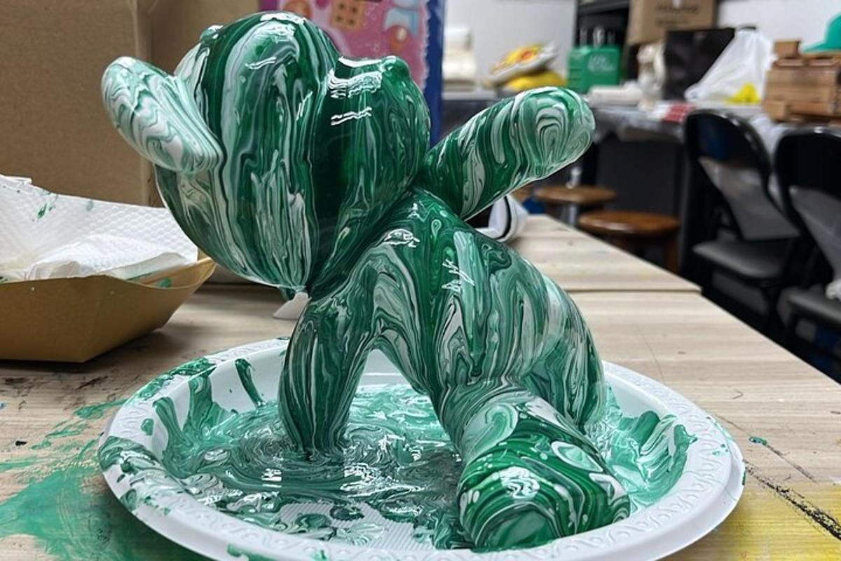 un orsacchiotto di vetro verde su un piatto su un tavolo