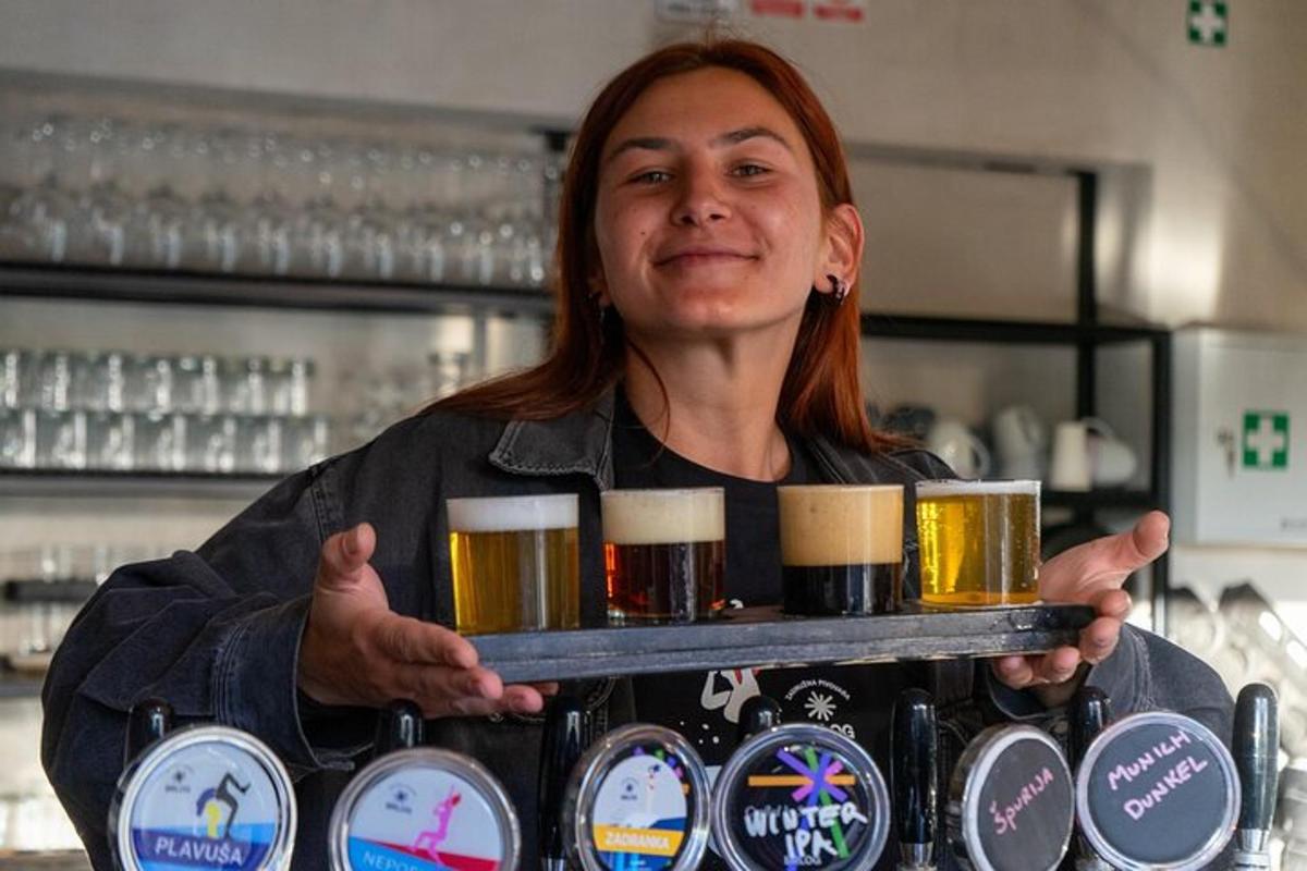 a woman holding a tray of beer glasses