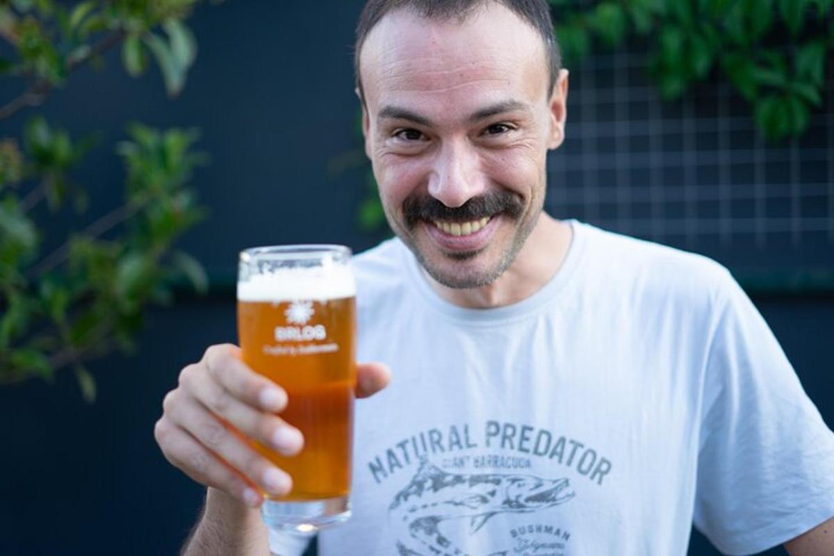 un home sosté un got de cervesa