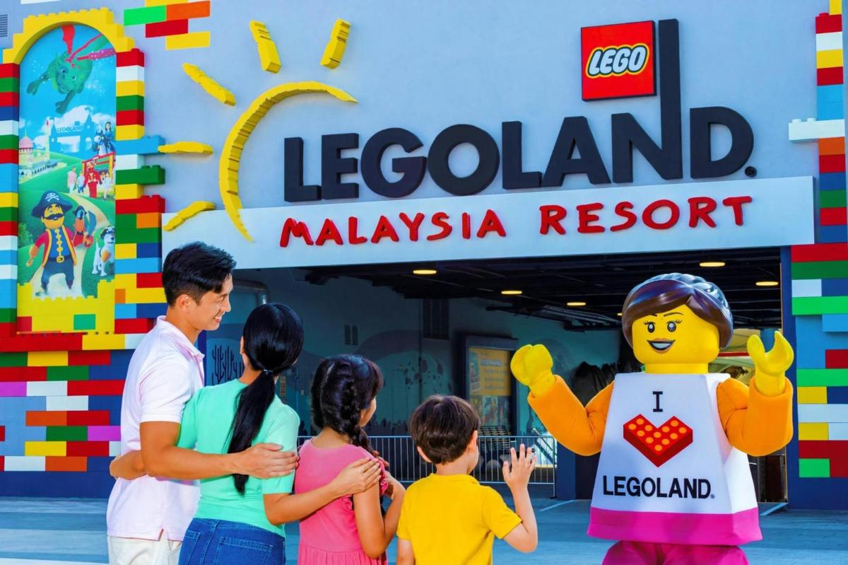 un grup de oameni care stăteau în fața complexului Legoland Malaysia