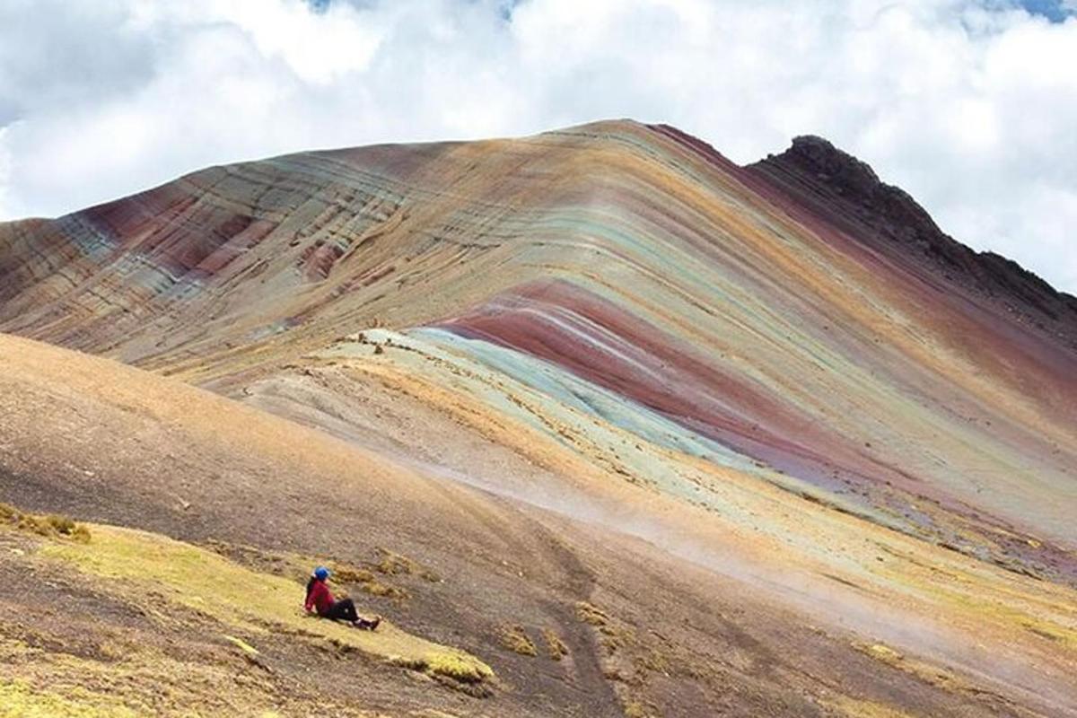 una persona seduta sul fianco di una montagna