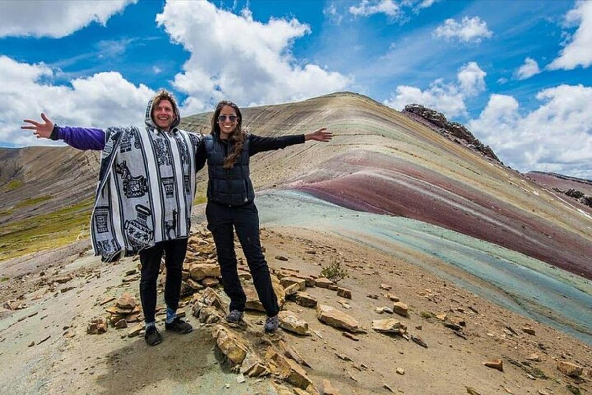un uomo e una donna in piedi sulla cima di una collina