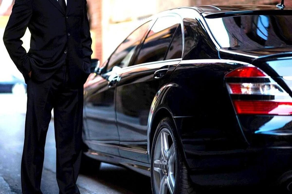 a man in a suit standing next to a car