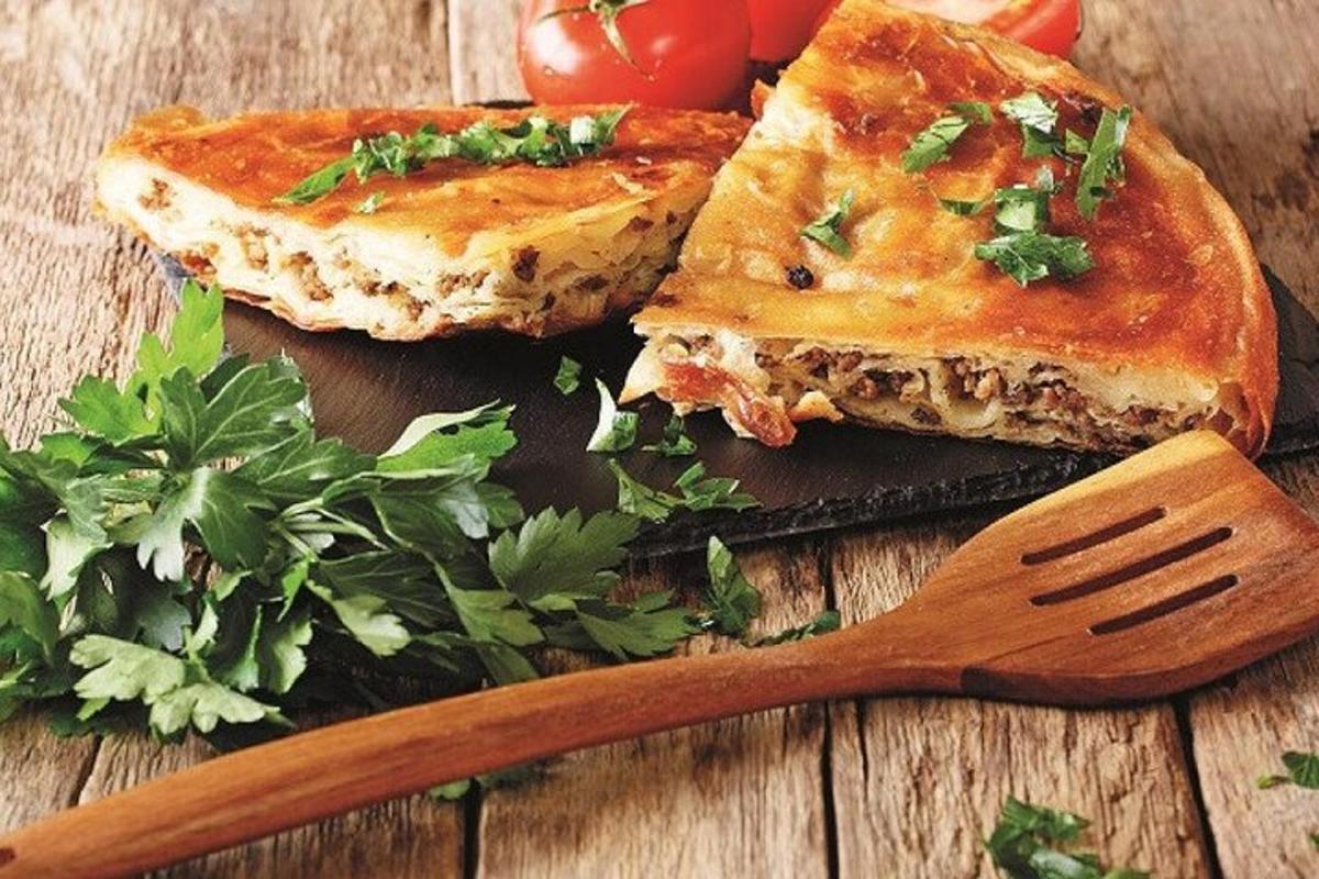 zwei Stücke Pizza auf einem Schneidebrett mit einem Spatel
