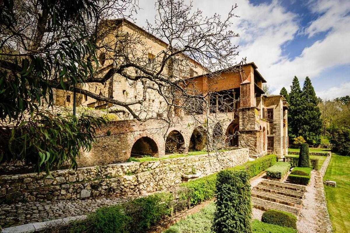 a large stone building with a stone wall and a garden