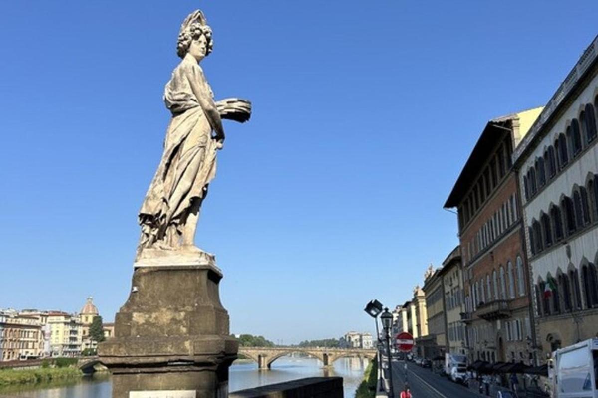 Una estatua de una mujer parada junto a un río.